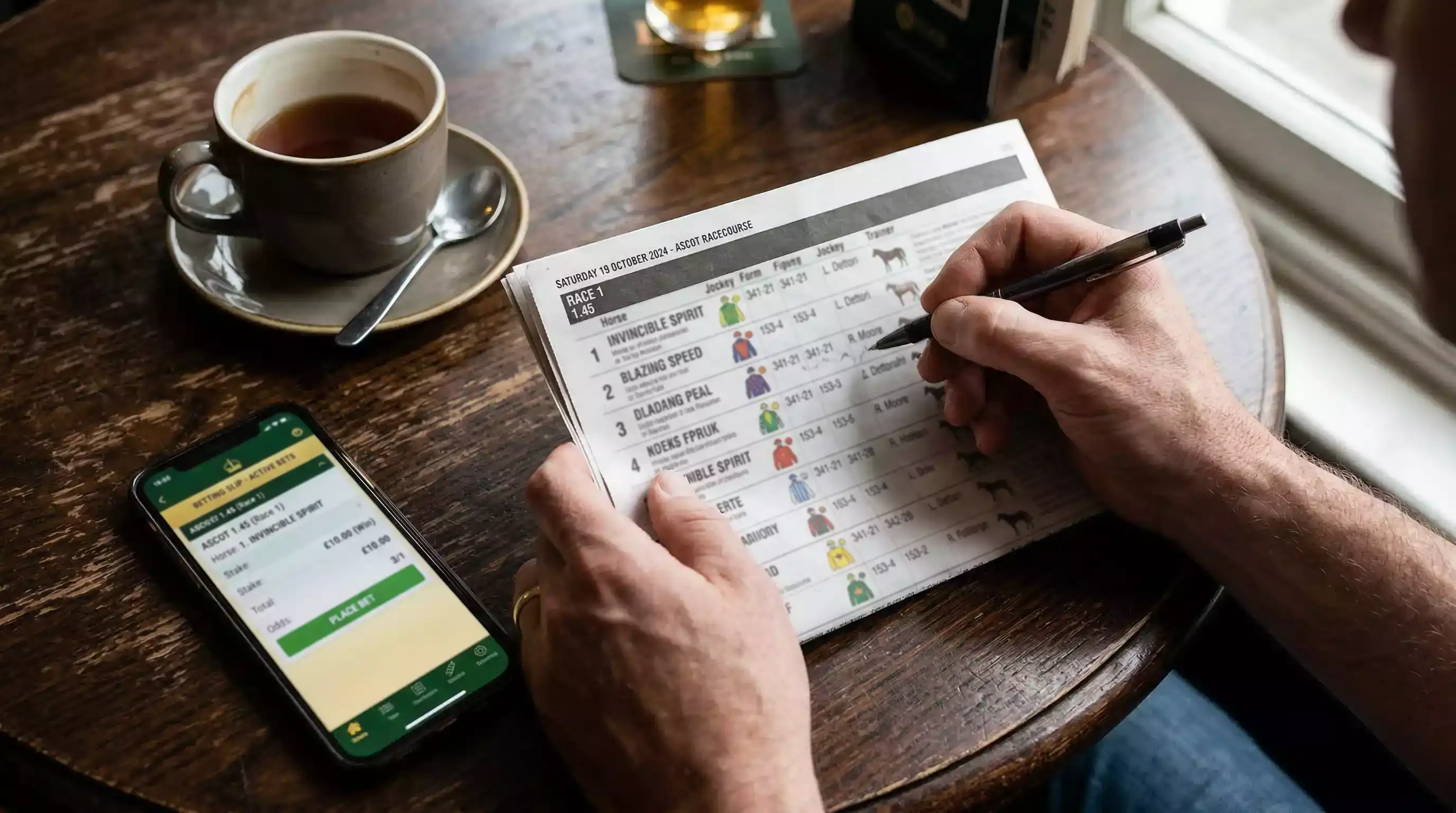 Punter studying a racecard before placing an online horse racing bet